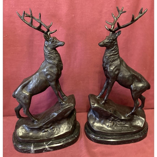 1052 - A pair of large marble based bronze figurines of stags.  Signature to base.  Approx. 43cm tall.