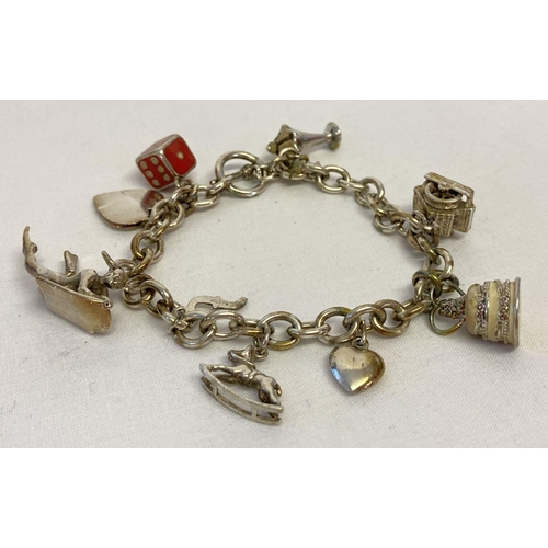 1062 - A silver charm bracelet with t bar clasp and 9 silver and white metal charms.  Charms include an ice... 