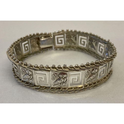 57 - A flexible silver panel bracelet with owl and Greek key decoration. Clasp needs attention.  Marked 9... 