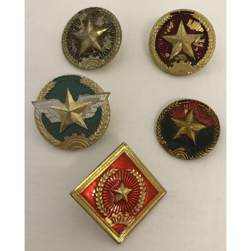 18 - A group of 5 Vietnam War era Vietcong and N.V.A. metal helmet badges. With screw back fixings. Large... 
