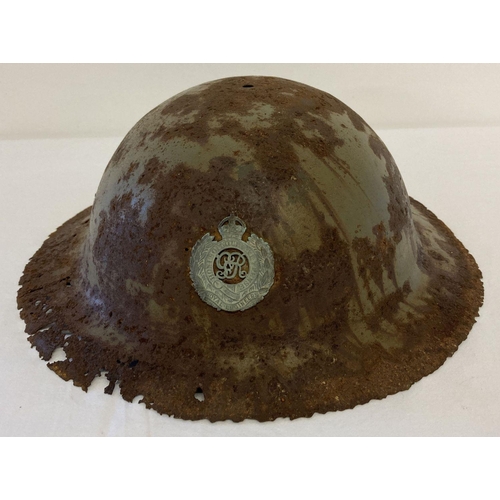 64 - A British WWI semi relic Brodie helmet with Royal Engineers Cap badge fixed to front. Helmet in rust... 
