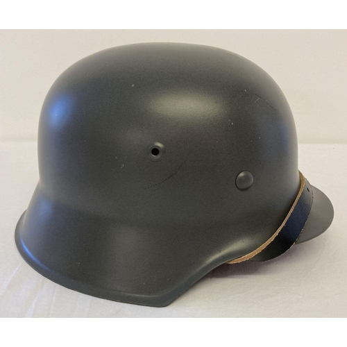 70 - A reproduction re-enactors German WWII M42 steel helmet with leather straps and liner. Marked ET-64 ... 