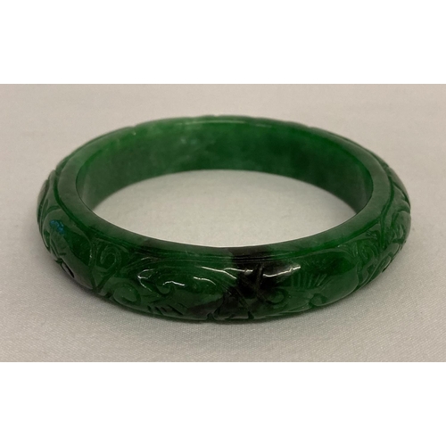 1013 - A Chinese green apple jade bangle with engraved detail.  Approx. 6.25cm interior diameter, 8cm overa... 