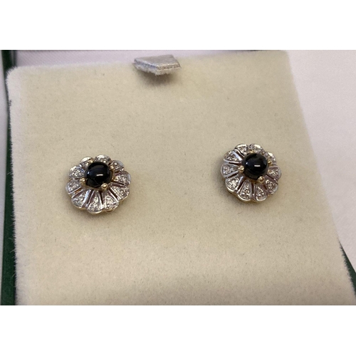 12 - A pair of 9ct gold Onyx and diamond set stud earrings, by Luke Stockley, London. Central round black... 