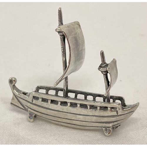 1112 - A miniature silver model of a sailing ship, marked 925.  Approx. 4cm tall x 4cm long.