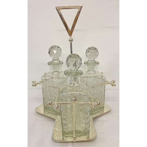 1113 - A silver plated triple decanter stand tantalus with 3 cut glass decanters. Central screw in stem wit... 