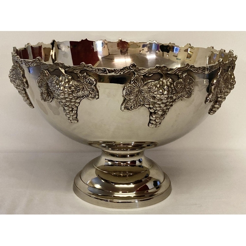 1116 - A large silver plated punch bowl with bunches of grapes detailed to rim of outer bowl. Raised on a p... 