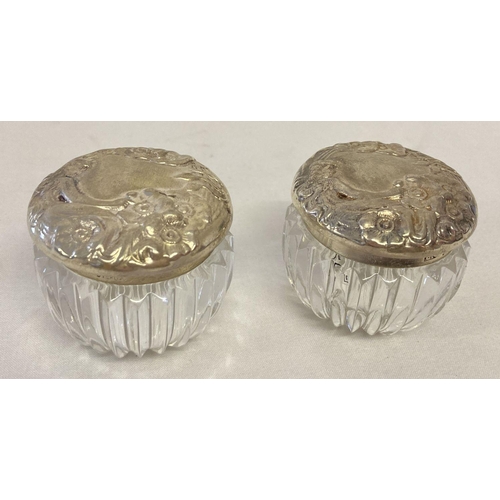 1117 - A pair of silver topped glass pots with Art Nouveau style detailed lids. Clear glass ribbed pots, ap... 