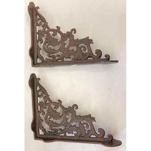 1144 - A pair of rust effect cast metal wall shelf bracelets, with decorative scroll & leaf design.  Approx... 