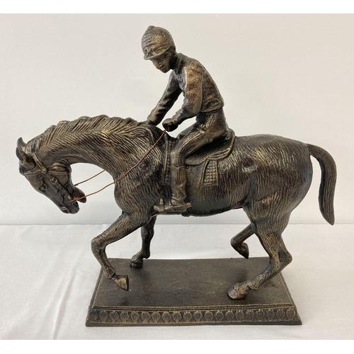 1148 - A large bronzed cast metal figurine of a horse and jockey.  Approx. 39cm T x 42cm L.