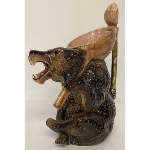 1165 - A large vintage ceramic majolica glaze honey bear jug with large spoon shaped handle. Dark brown col... 