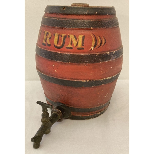 1167 - A vintage red and black painted stoneware rum barrel with original brass tap.  Approx. 25cm tall.