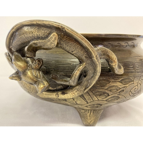 1197 - A large vintage Chinese 2 handled censer with decorative dragon shaped handles. Raised on tripod fee... 