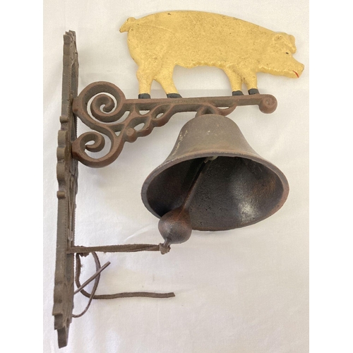 1338 - A painted cast metal wall hanging garden bell with pig design.  Approx. 34cm x 28cm.
