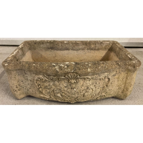 1356 - A stone trough style garden planter with carved cherubs and floral detail to front. Drainage hole to... 