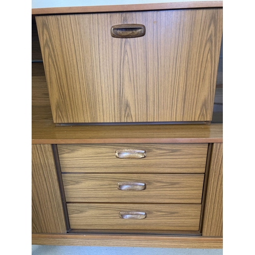 71 - A vintage mid century Schreiber teak sideboard with sliding doors, drawers and glass shelves. Raised... 