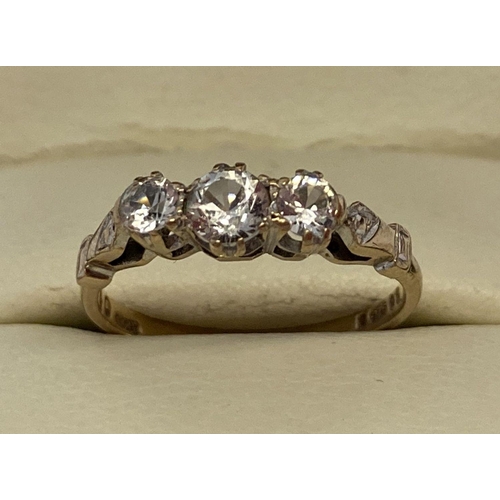 1006 - A vintage 9ct gold clear stone set trilogy ring with decorative detail to shoulders. Hallmarks to in... 