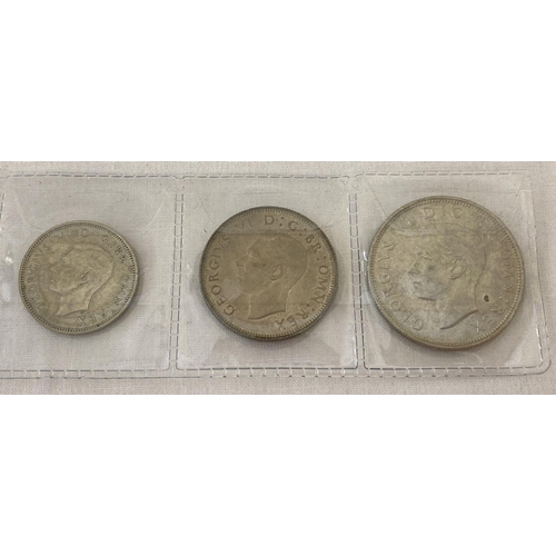 64 - A half silver George VI half crown, two shilling and one shilling coin, all dated 1945.