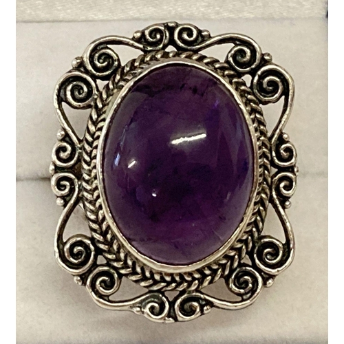 1015 - A large statement silver dress ring set with an oval amethyst cabochon stone. Marked 925 to inside o... 