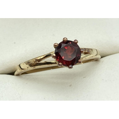 1055 - A silver gilt solitaire ring set with a round cut garnet. Marked 925 to inside of band. Stone approx... 