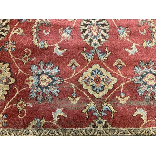 1405 - A modern Ziegler floral patterned rug. Red ground with black, blue, beige and green design.
