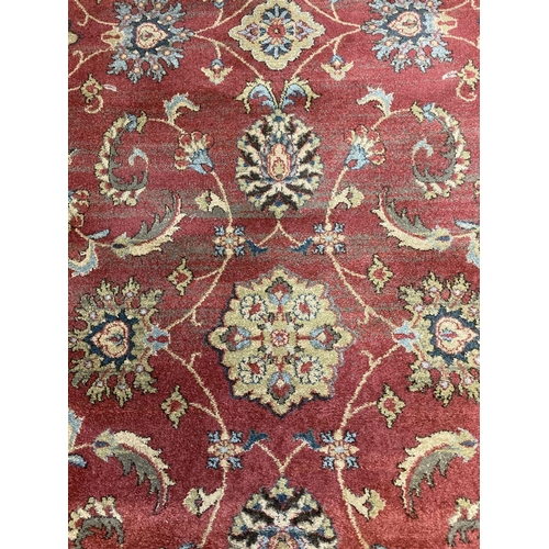 1405 - A modern Ziegler floral patterned rug. Red ground with black, blue, beige and green design.