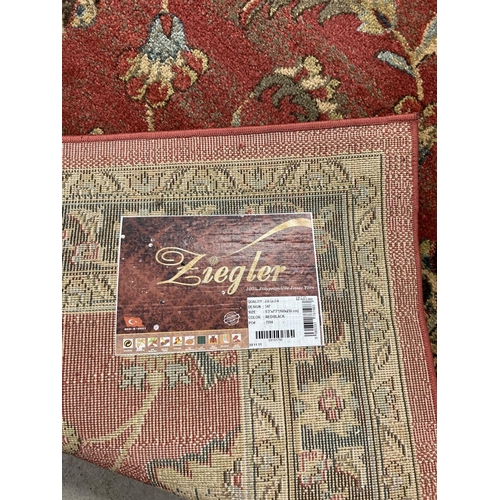 1405 - A modern Ziegler floral patterned rug. Red ground with black, blue, beige and green design.