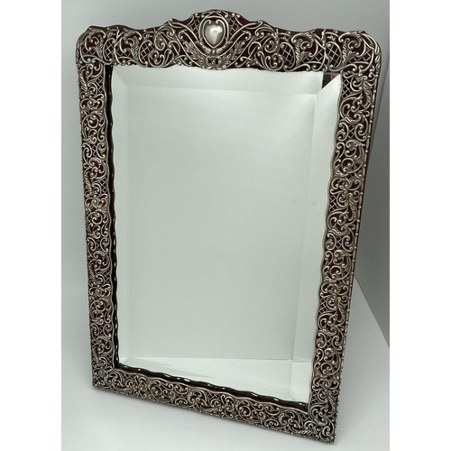 1120 - A large Victorian ornatley framed silver dressing table mirror with empty shield shaped cartouche. R... 