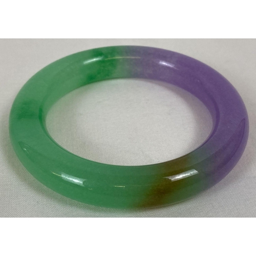 223 - A chunky lavender jade bangle of green and lilac tones. Approx. 8.5cm diameter, 6cm inner diameter.