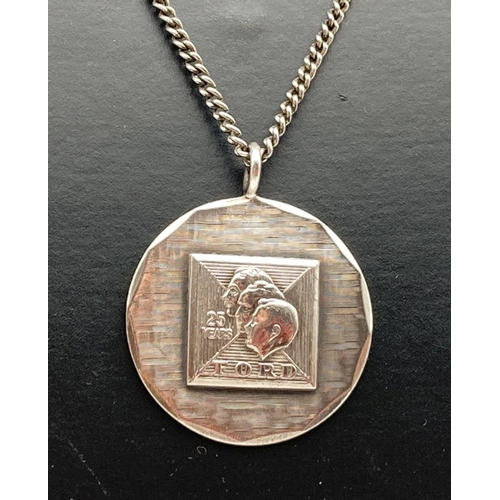 63 - A vintage silver circular pendant commemorating 25 years of service for Ford. On an 18 inch curb cha... 