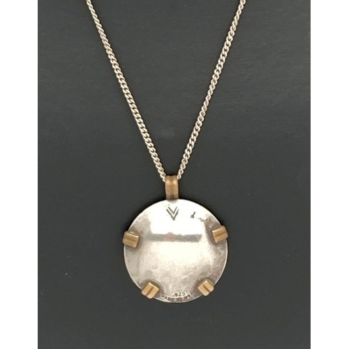 66 - A contemporary design American silver and brass circular pendant on an 18 inch curb chain. Pendant m... 