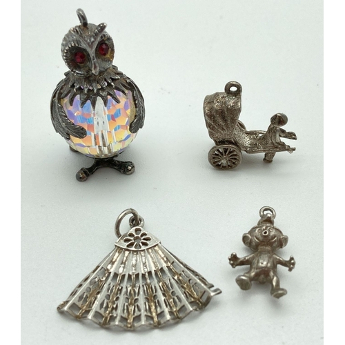 76 - 4 vintage silver and white metal charms. A small Imp, a fan, a rickshaw and an owl with crystal body... 