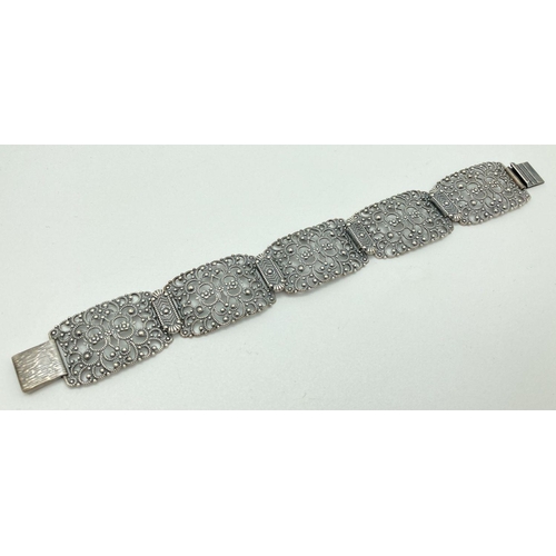 80 - A vintage silver bracelet with 5 pierced work panels of floral decoration and push clasp. 925 stampe... 