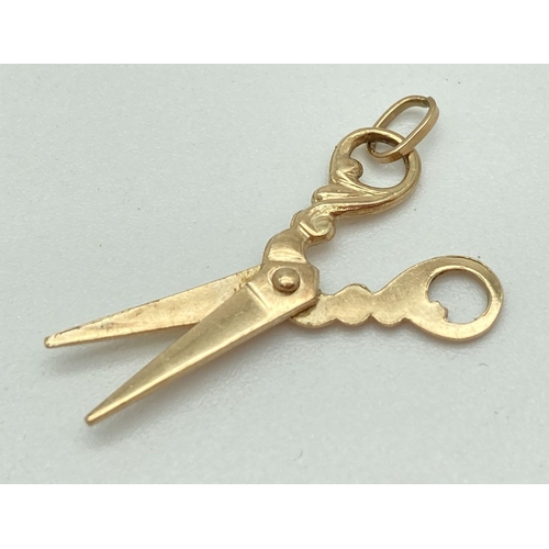 103 - A 9ct gold charm/pendant in shape of a pair of scissors with scroll detail handles. Approx. 2.5cm lo... 