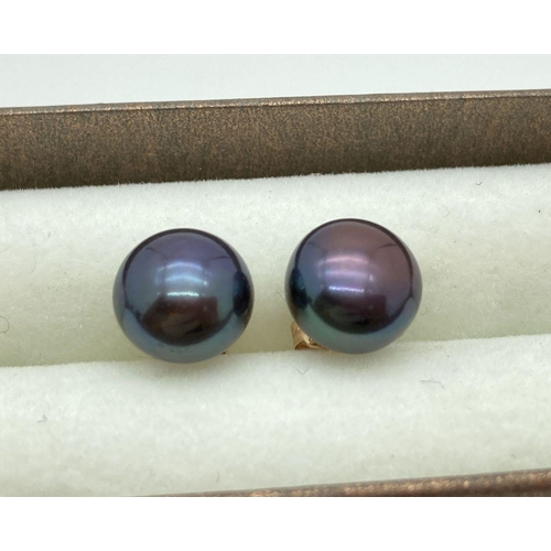 121 - A pair of 14ct gold and peacock pearl stud earrings. Approx. 8mm diameter. Gold marks to both butter... 