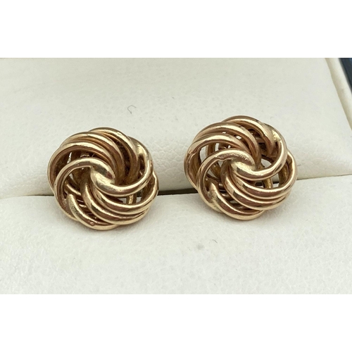 122 - A pair of 9ct gold knot style stud earrings with butterfly backs. Gold marks to posts. Total weight ... 