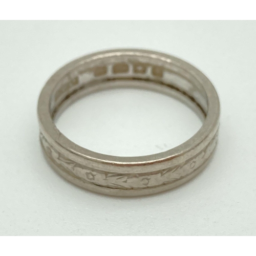 146 - An 18ct white gold 44mm patterned wedding band. Full hallmarks to inside of band. Total weight appro... 