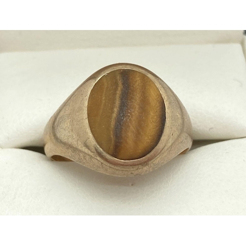 164 - A men's 9ct gold signet ring set with a round Tigers Eye stone. Total weight approx. 4.4g. Ring size... 