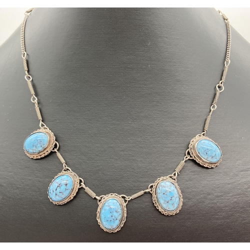 275 - A vintage white metal necklace set with 5 oval mottle patterned blue stones. Approx 18 inches long.