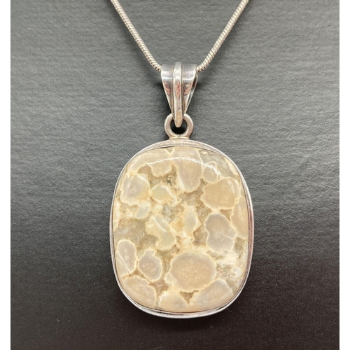 176 - A silver square shaped pendant set with ocean jasper, on an 18