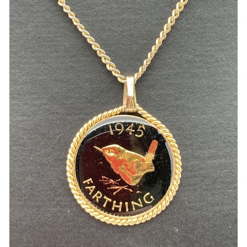 276 - A 1945 farthing that has been coloured and enamelled, set in a gold tone pendant mount on a gold ton... 