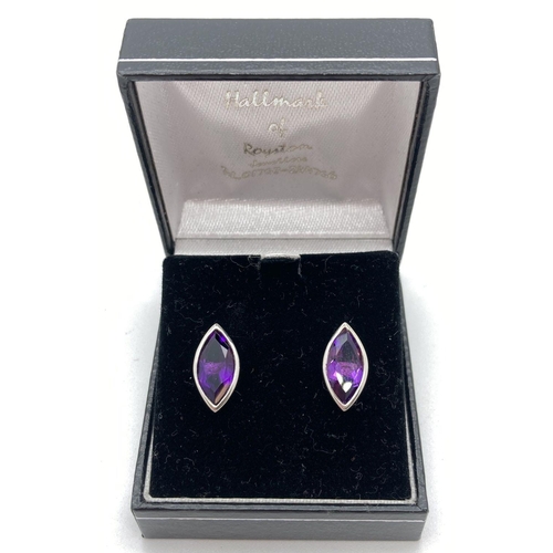 220 - A boxed pair of amethyst set silver stud style earrings. Marquise cut amethysts approx. 1.2cm x 0.5c... 