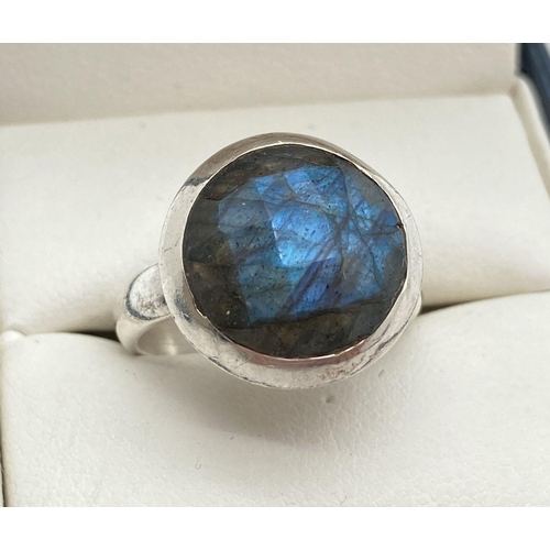 180 - A modern design silver dress ring set with a round cut faceted labradorite stone. Ring size M. Band ... 