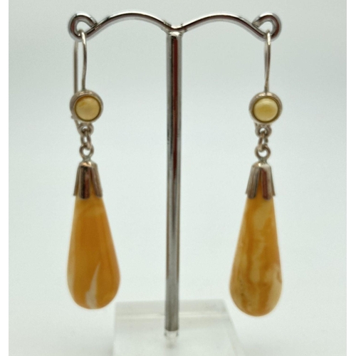 181 - A pair of silver and butterscotch amber drop style earrings with safety clips to hook posts. Marked ... 