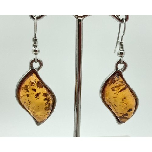 184 - A pair of modern design white metal and amber drop style earrings. Total length excluding hooks 3cm.