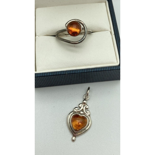 185 - A small spiral design ring set with a round amber cabochon. Together with a modern design heart shap... 