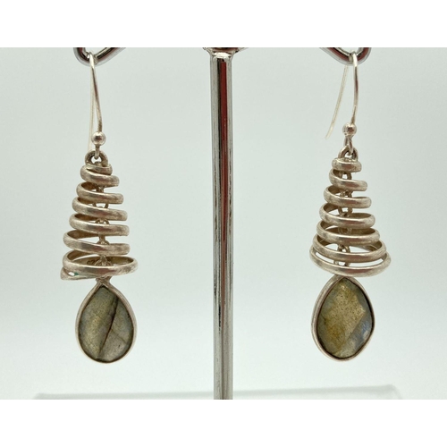 186 - A pair of modern design silver and labradorite drop style earrings. A spiral design cap with oval cu... 