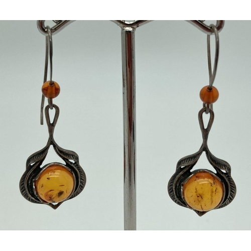 190 - A pair of white metal and amber drop style earrings. Small amber bead to hooks with amber cabochons ... 