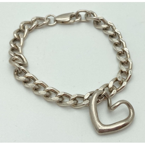 192 - A silver curb chain bracelet with lobster clasp and floating heart charm. Both clasp and heart marke... 