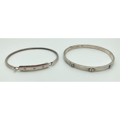 196 - A Mexican silver Love style hinged bangle. Together with a 925 silver bangle with lilac stone set pa... 